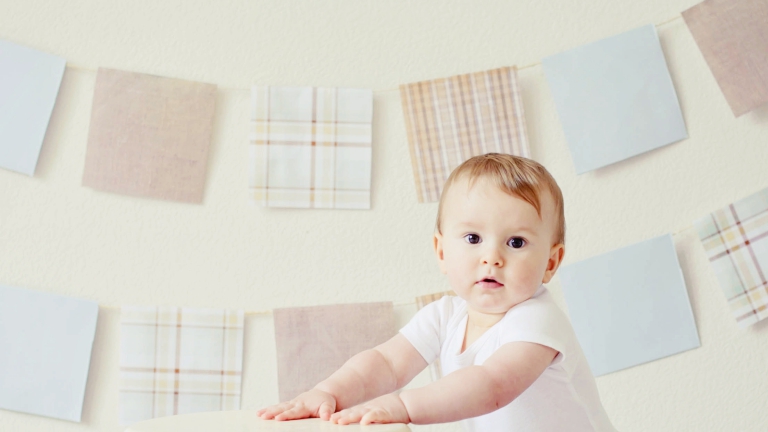 adorable baby with washcloths in background
