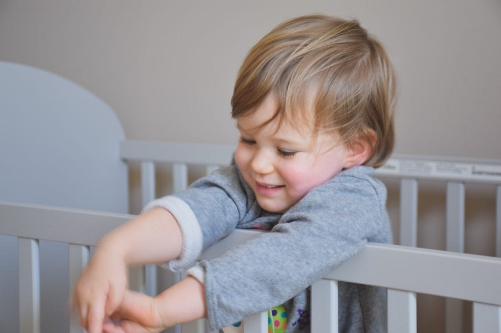 child in a toddler bed rail