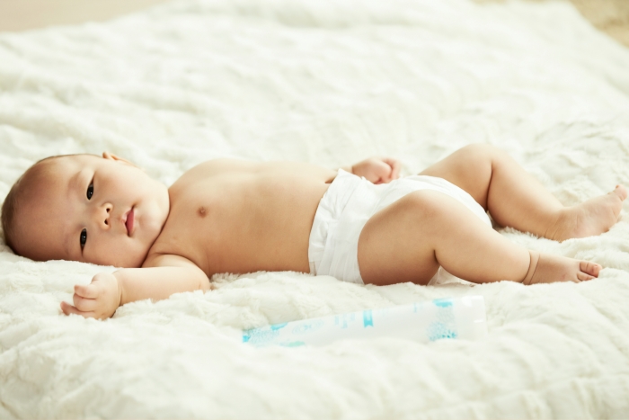 baby in cloth diaper on bed